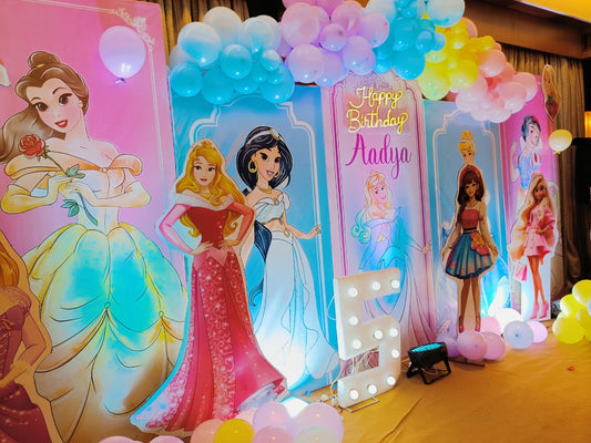 Decorative setup with princess cutouts and balloons for a birthday party.