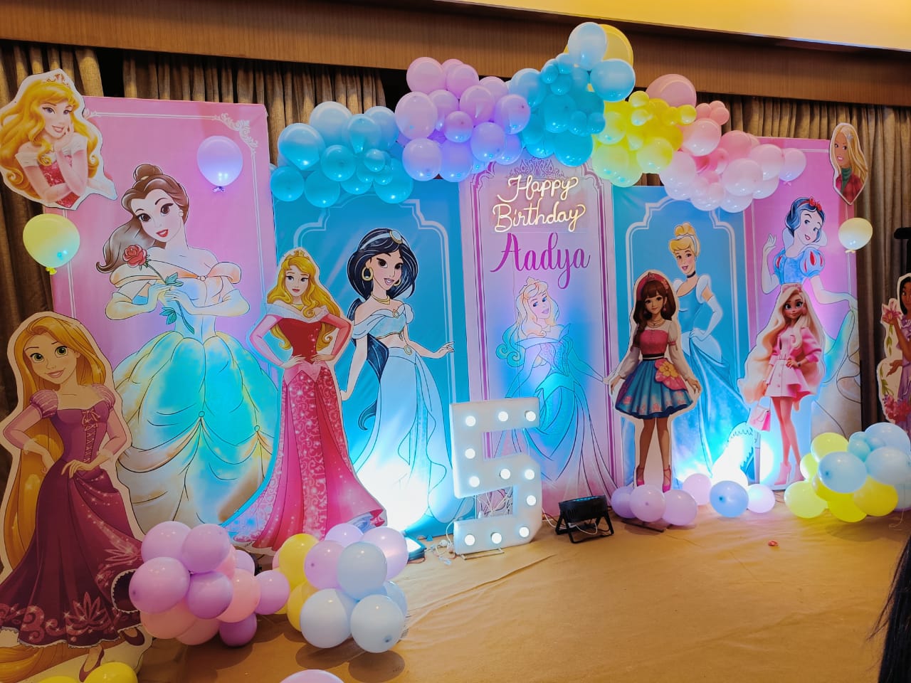 Decorative setup with princess-themed balloons and signs for a birthday party.